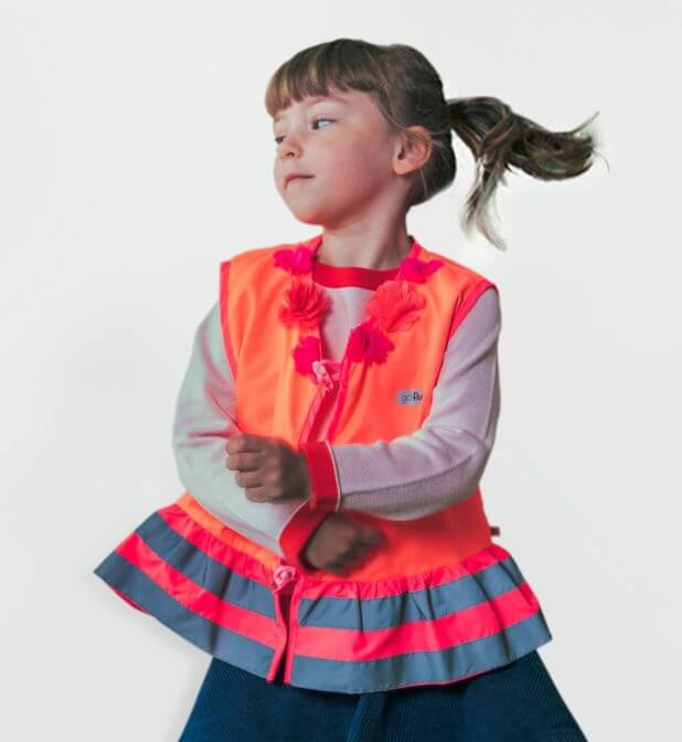 Young girl wearing hi-vis vest Rosie with flowers